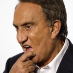 In this photo taken on Sept. 27, 2010, Italian journalist Emilio Fede touches his chin, in Milan, Italy. A Milan court, Friday, July 19, 2013 has convicted three of ex-premier Silvio Berlusconi's former aides of procuring prostitutes for the media mogul's infamous "bunga bunga" parties. The court Friday handed out stiff sentences to Emilio Fede, a longtime executive in the mogul's TV networks; Dario Mora, a talent agent, and Nicole Minetti, a former regional politician who professed love for the ex-premier. Berlusconi wasn't on trial in this case, but was convicted separately last month of paying for sex with a minor and trying to cover it up. Prostitution among adults is legal but exploiting prostitutes is a crime. (AP Photo/Luca Bruno)